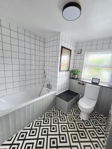 a white bathroom with a tub and a toilet at 12 Ivy Cottage in St Ives +9 photos