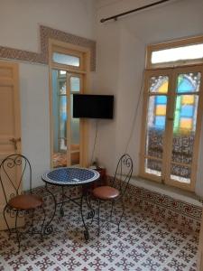 a room with a table and chairs and a tv at dar rachid in Fez