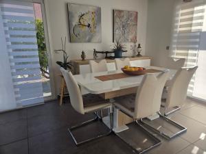 a dining room with a white table and chairs at Chez Titelle in Saint-Laurent-de-la-Salanque