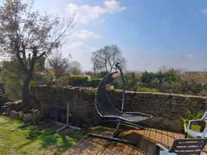 a chair sitting on a patio next to a stone wall at Le repos beaurepairien in Beaurepaire