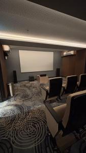 a conference room with chairs and a white screen at Sorici Studio at Bella Tower in Surabaya +8 photos