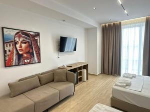 a living room with a couch and a tv at Moonlight Hotel in Vlorë