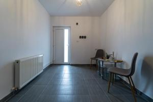 an empty room with a table and chairs and a door at Vila Petro in Iaşi