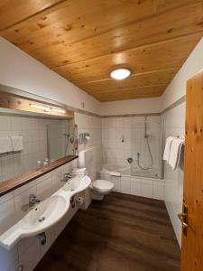a bathroom with two sinks and a toilet and a shower at WILDAUERS Ansitz Haidenhof STAY & SLEEP in Lienz +79 photos
