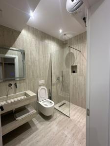 a bathroom with a shower and a toilet and a sink at Moonlight Hotel in Vlorë +94 photos