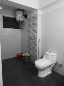 a bathroom with a white toilet in a room at Hotel Kabur in Pelling +24 photos