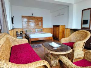 a bedroom with a bed and a table and chairs at Hotel Kabur in Pelling