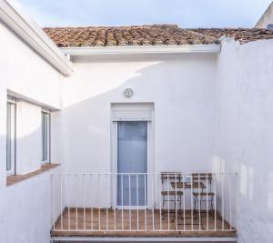 un balcón de una casa blanca con sillas. en Ca La Josefa, en Balaguer
