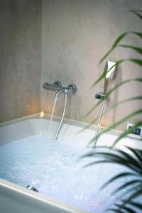 a bath tub filled with water with a faucet at La parenthèse lilloise in Lille