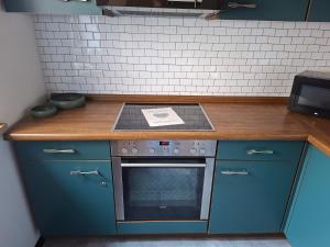 a kitchen with blue cabinets and a stove top oven at Gutheils-Ferienwohnung in Nanzdietschweiler