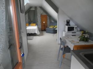 a room with a kitchen and a room with a table at chambre d'hôte équipée en studio in Molliens-Vidame