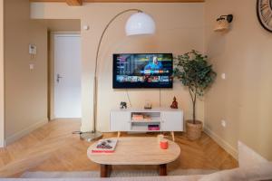 a living room with a flat screen tv on the wall at La parenthèse lilloise in Lille