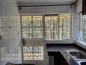 a kitchen with glass doors and a sink and a counter at WeniZani Backpackers Hostel Nairobi in Nairobi