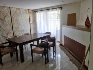 a dining room with a wooden table and chairs at WeniZani Backpackers Hostel Nairobi in Nairobi +64 photos