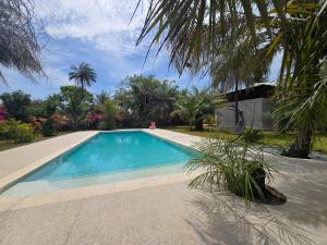a swimming pool in front of a house at La Maison Ardiana in Oussouye
