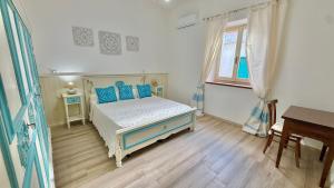 a bedroom with a bed with blue pillows and a table at Casa vacanze Nuraghe Orosei in Orosei