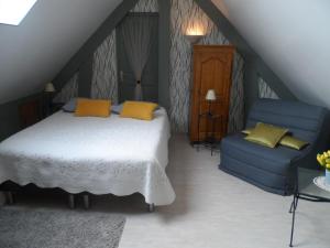 a bedroom with a bed and a blue couch at chambre d'hôte équipée en studio in Molliens-Vidame