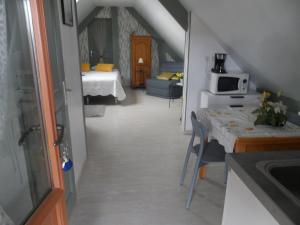 a kitchen and a living room with a table at chambre d'hôte équipée en studio in Molliens-Vidame