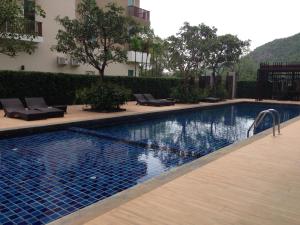 a swimming pool with lounge chairs next to a building at Baan Khao Yai Condo in Mu Si