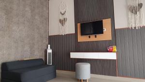 a living room with a tv on a wall at Nyoman Guest House in Singaraja +11 photos