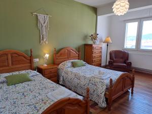 a bedroom with two beds and a chair at Torre Plaza 5 in Boiro