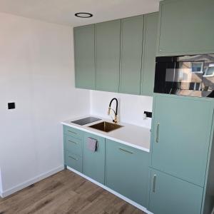 a kitchen with blue cabinets and a sink at Apartament "Agatka" in Hel