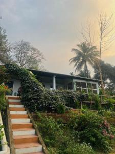 a house with a staircase leading up to it at Org Retreat & Farmstay in Guwahati +29 photos