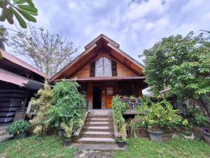 a house with stairs in front of it at Palanta Roemah Kajoe Syariah Villa in Kampungdurian