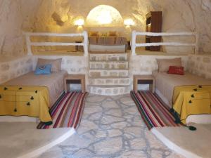 a room with two beds and two tables in it at Dar Zmen Toujane in Tūjān +47 photos