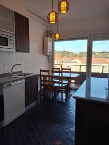 a kitchen with a table and chairs and a kitchen with a view at Torre Plaza 4 in Boiro +25 photos