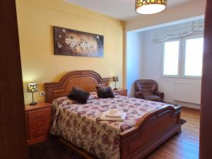 a bedroom with a large bed and a chair at Torre Plaza 4 in Boiro