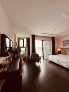 a hotel room with a bed and a desk and chair at Sapphire Residence Hạ Long in Ha Long