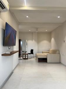 a living room with a couch and a tv on a wall at SeaYou Stay in Daman