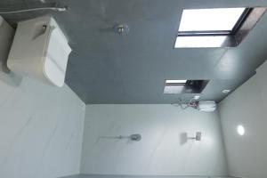 a bathroom with a toilet and a window at SeaYou Stay in Daman