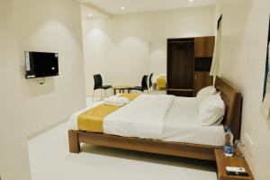 a bedroom with a bed and a table and chairs at SeaYou Stay in Daman