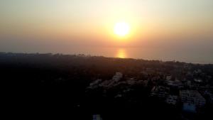 a view of the sun setting over a city at SeaYou Stay in Daman