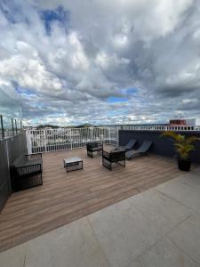 a patio with benches and tables on a roof at Studio Sereno in Barbacena