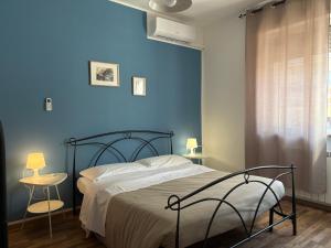 a bedroom with a bed with a blue wall at B&B D'Amare in San Salvo