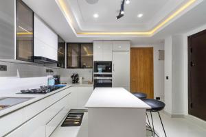 a kitchen with white cabinets and a white counter top at Saka in Lekki