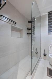 a white bathroom with a shower and a toilet at Saka in Lekki