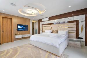 a bedroom with a large bed and a flat screen tv at Saka in Lekki