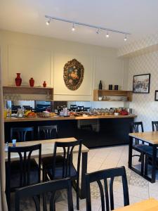a restaurant with tables and chairs and a kitchen at Hotel Maj Inn in Moravske-Toplice