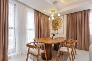 a dining room with a wooden table and chairs at Saka in Lekki +20 photos