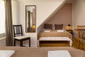 a bedroom with a bed and a mirror at KEFS Guesthouse & Café in Ærøskøbing