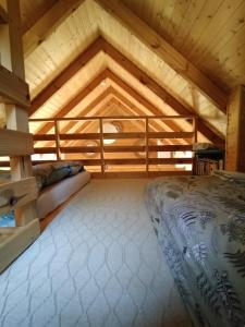 ein großes Zimmer mit einem Bett in einer Holzdecke in der Unterkunft Ulęgałki Roztocze in AdamÃ³w