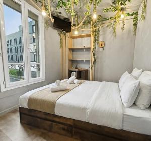 a bedroom with a large bed with white sheets and pillows at Petit nid douillet, à deux pas des commodités in Neuilly-Plaisance