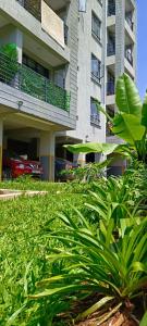 a building with a lot of green plants in front of it at BlueByMis Studio Apartment in Muchatha