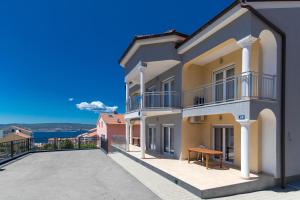 a balcony of a house with a bench on it at Apartment Dea 3 Spacious Lower-Level Apartment in Crikvenica
