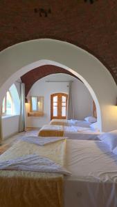 two beds in a room with an arch at Luxor Family Home in Naj‘ ar Rizqah +19 photos