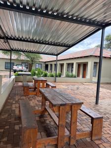 a picnic table and benches under a metal canopy at Northam Square Mine Contractor Accommodation in Northam